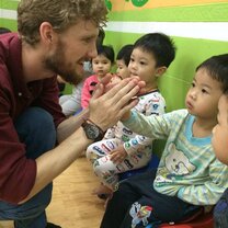 Teaching English in Vietnam man high-fiving little kid